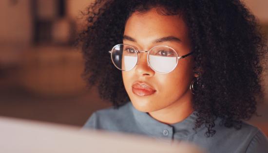 A woman looks at a computer screen.